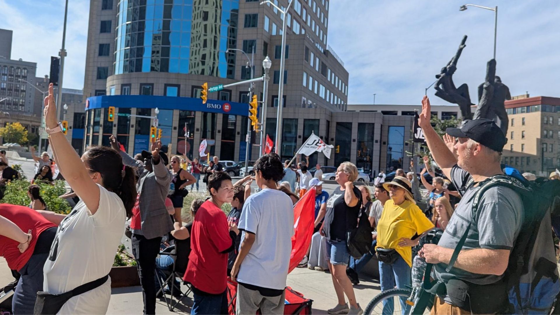 A crowd of people on the sidewalk at Portage & Main in downtown Winnipeg
